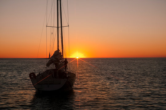 Silhouette of unknown woman on the sailing boat in the sunset background, near island Unije, Croatia, the Adriatic sea.Image.