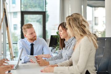 Small group of business people sitting at table and having meeting. Multi cultural group.
