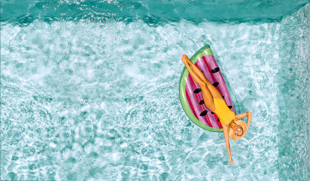 Woman Relaxing On Inflatable Lilo In Hotel Pool