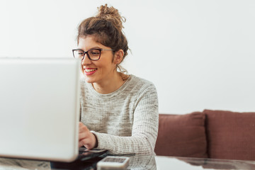 Young woman working at her home. She working at lap top