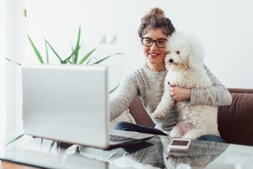 Young woman working at home. She is with her dogs