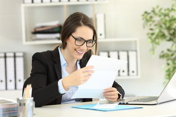 Obraz na płótnie Canvas Happy office worker reading a letter