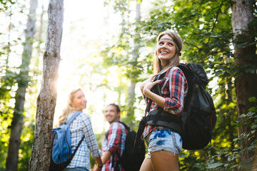 Beautiful woman and friends hiking in forest