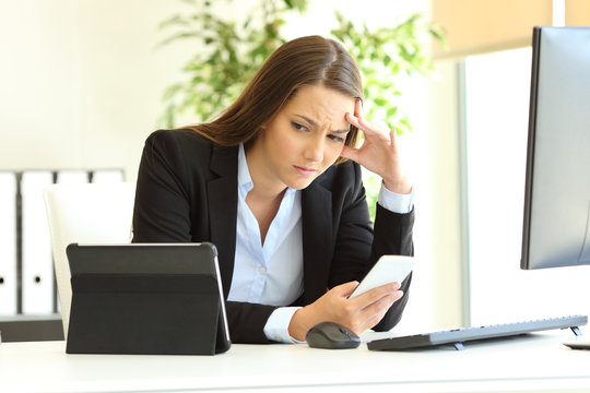 Worried office worker using multiple devices