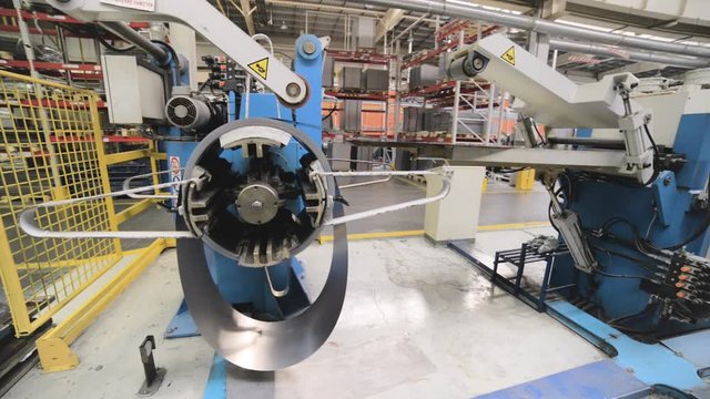 Cold rolled steel coil on decoiler of machine in metalwork manufacturing.