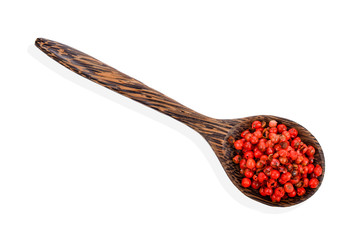 dried pink peppers in wood spoon isolated on white background