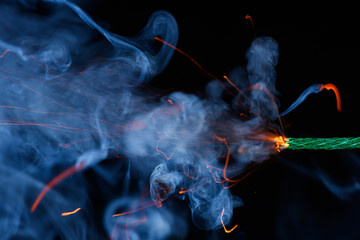 Fuse burning with sparkles and smoke on black background. Dynamite petard firecracker green fuse.