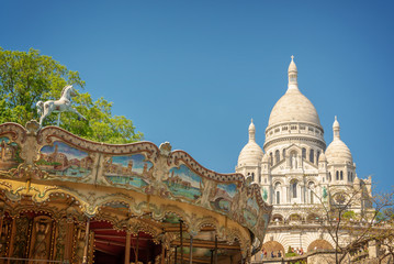 Vintage carousel and the Basilica of the Sacred Heart in Montmartre, Paris France