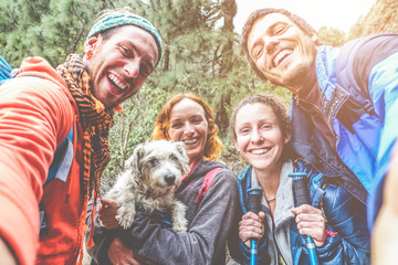Happy trekkers people taking selfie for social network story with their dog - Main focus on men faces - obrazy, fototapety, plakaty