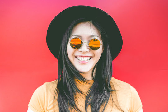 Portrait of happy asian girl smiling with vintage sunglasses - Focus on  glasses