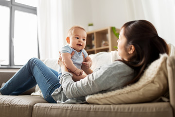 family and motherhood concept - happy young asian mother with little baby son at home