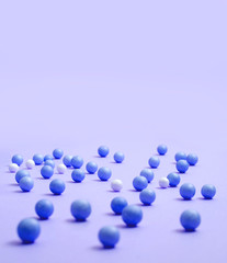 Blue and white balls are scattered on the lilac surface