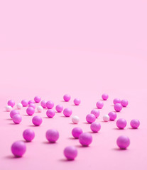 Pink and white small balls are scattered on the pink surface