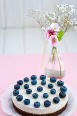 vegan cake next to a vase with flowers