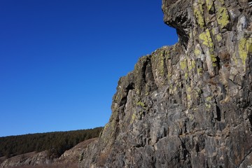 Mountain cliffs on the bank of the river against the blue sky