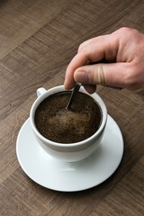 preparing hot coffee into a white mug