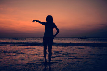Fototapeta premium Silhouette of a girl in sunset / sunrise time over the ocean.