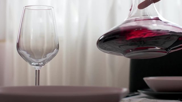 Pouring red wine from the count into a cup of slow motion