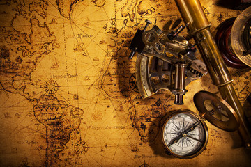 Fototapeta na wymiar Top view of vintage navigation equipment on old world map.