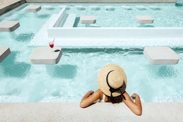 Girl drinking fruit cocktail in pool