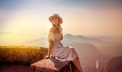 carefree female relaxing on top of the mountains