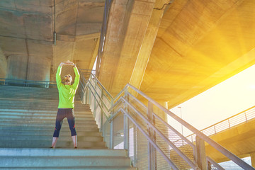 Sportsman working out / jogging on a big city urban bridge.