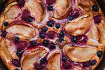 Delicious authentic hand-made homemade pie with apples and berries on a pink background texture. baking recipe to cook