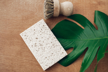 Zero waste concept, flat lay. Reusable natural cellulose sponge and eco wooden brush on wooden...