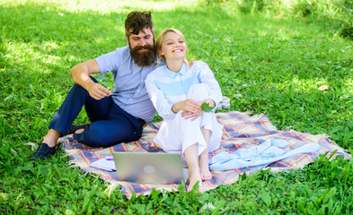 Relax and inspiration concept. Couple with laptop relax natural environment. Family enjoy relax nature background. Couple bearded man and blonde woman relax nature while sit on green grass meadow