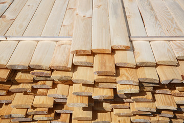 Pile of raw wood planks. Building process, construction site, carpentry, dry building industry concept.