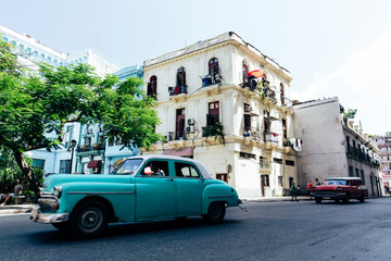 Vintage american cars driving on the street in downtown Havana