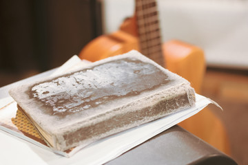 old shabby tattered book on yellow guitar background, author's song