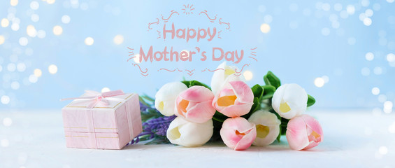 Phrase Happy Mother's Day on a bright background with flowers, bouquet, gift box. Congratulate this postcard.