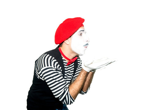 Man in striped sweater, white gloves sending air kiss. Clown, artist , mime. Isolated on white background