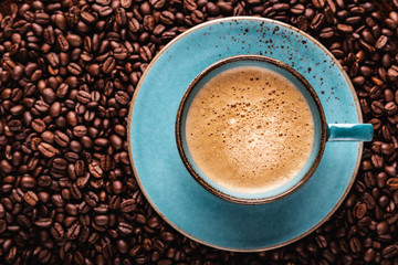freshly brewed coffee crema in a cup on coffee beans bedded