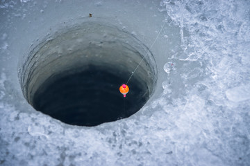 Winter fishing float fishing rod on the worm. © Taras