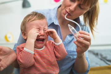 little boy does not want to clean his nose