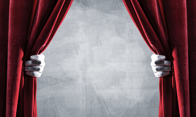 Concrete wall behind drapery curtain and hand opening it