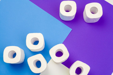 Rolls of toilet paper on color background, top view
