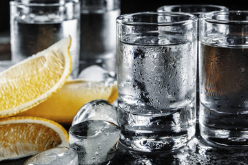 Vodka in shot glasses on rustic wood background