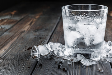 Vodka in shot glasses on rustic wood background