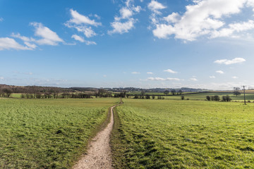 Blue skies and clouds over the field path