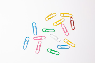 Colored paper clips on white background
