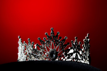 Silver Diamond Crown of Miss Pageant Beauty Universe World Contest sparkle light on black pillow, ready for wear Most beautiful Winner, studio lighting super red gradient background dramatic © Jade