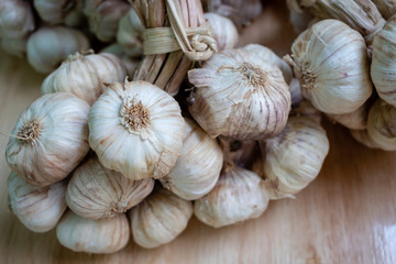 Pile of white garlic heads on wood background