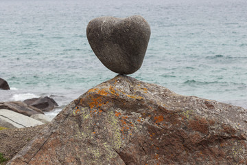 A boulder in incredible equilibrium and its supporting rock on Uttakleiv Beach, a scenic beach near Leknes of the Lofoten Islands