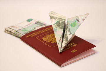 Airplane made of banknote, lying on the passport with money