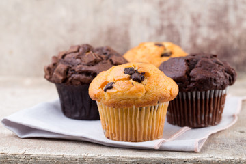 Homemade muffins with chocolate, vintage background.