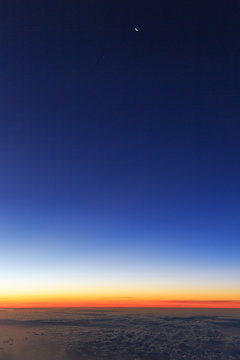 Beautiful aerial sunrise cloudscape with a new moon in the blue morning sky in the Netherlands