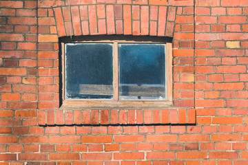 Small window in the middle of a red brick wall